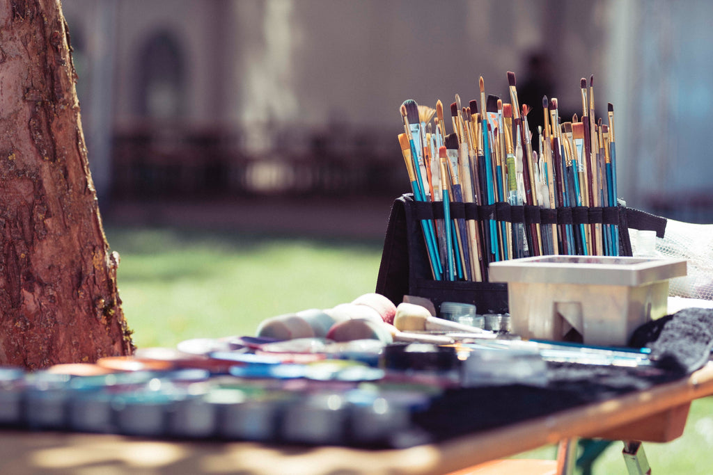 close up of painting supplies on a desk outside