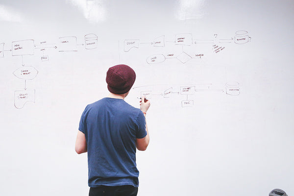 guy drawing flowcharts on a whiteboard