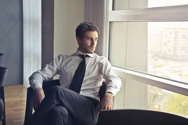 depressed businessman looking out the window of his office
