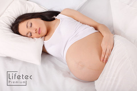 Zwangere vrouw slaapt op haar zij 