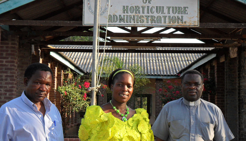 3 people standing in front of a college sign in Zimbabwe