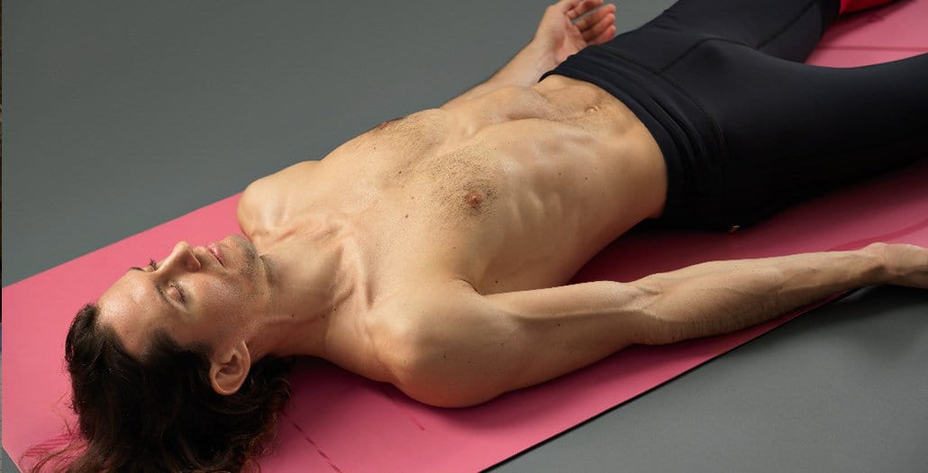 Male Yogi in Yoga Corpse Pose on a Liforme Yoga Mat Pink