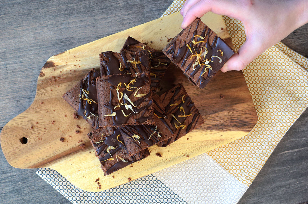 A hand picking up an Earl Grey and Orange brownie