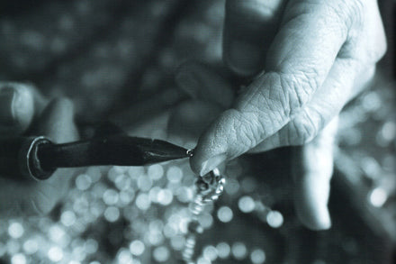 close up artisan hand linking beads