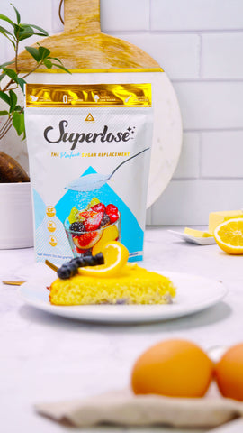 a piece of the blueberry lemon cake on a plate in front of the Superlose® package