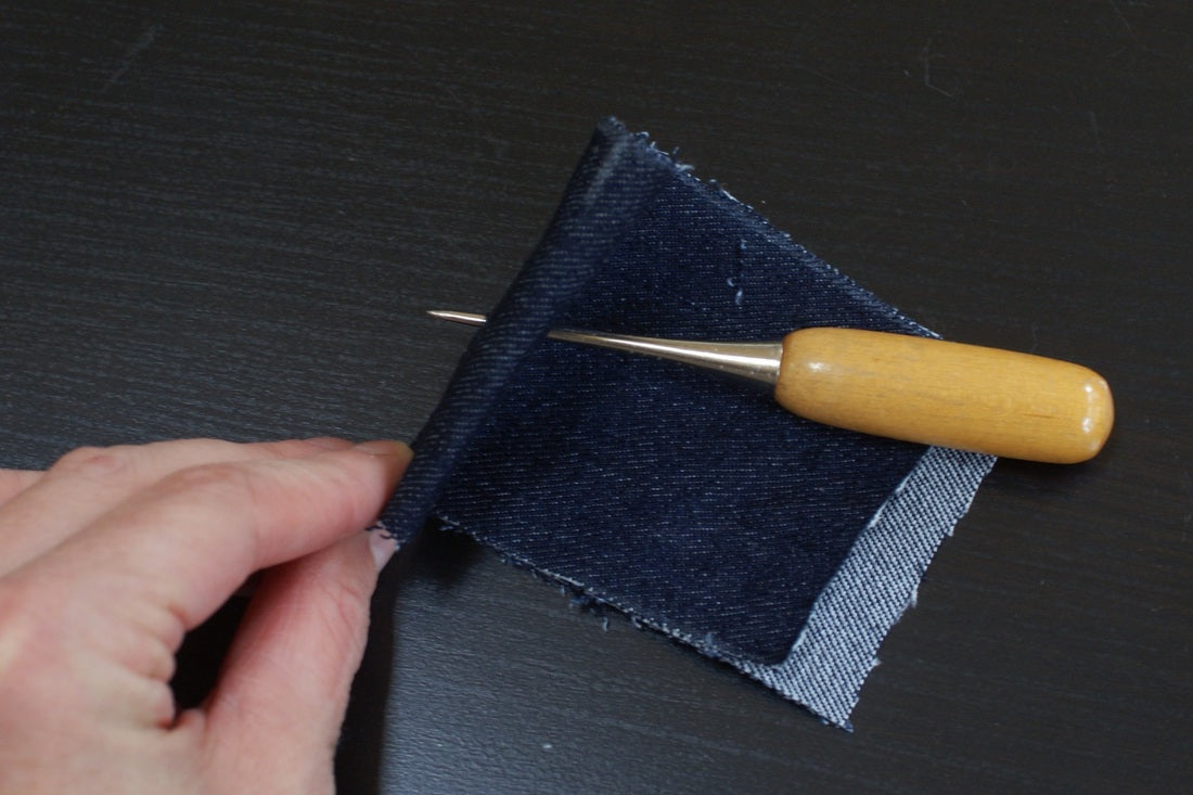 using an awl to install jeans buttons