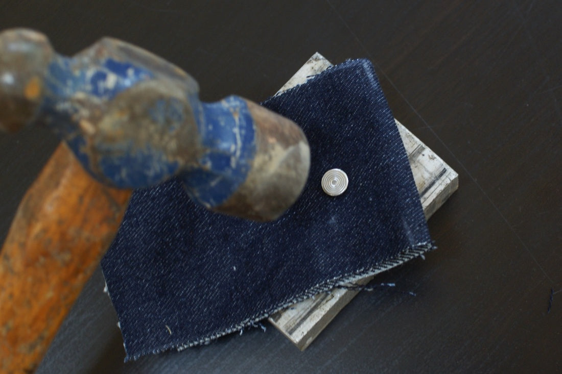 installing rivets in jeans with a hammer