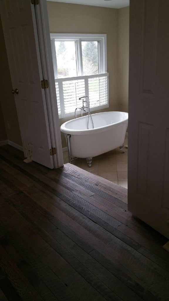 Wood floors in master bedroom with french doors opening up to a bathroom
