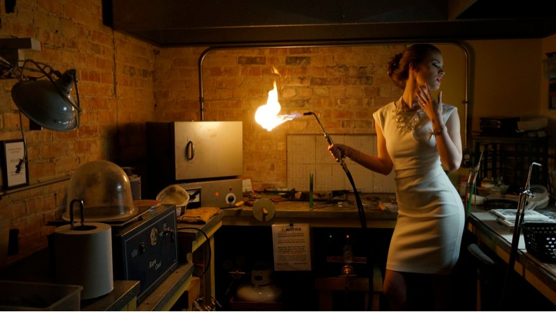 Woman in a white dress holding a blowtorch