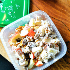 Cheesy waldorf salad in a plastic container, ready for the fridge