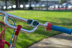 SunSnap Kids Sunglasses slapped on bicycle handlebars 