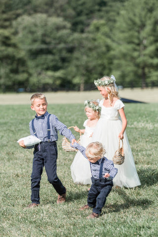 Flower girls walking down the aisle wearing Annabelle ivory classic style dresses Ana Balahan and ring bearers 