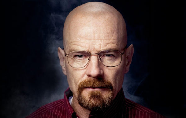Bryan Cranston bald with beard and reading glasses