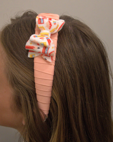 Back to School mini felt bow affixed to a headband with light coral ribbon wrapped around it
