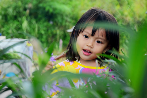 Little Asian girl in tropical foilage