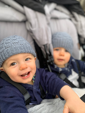 Twin babies smiling in Mountain Buggy duet in silver