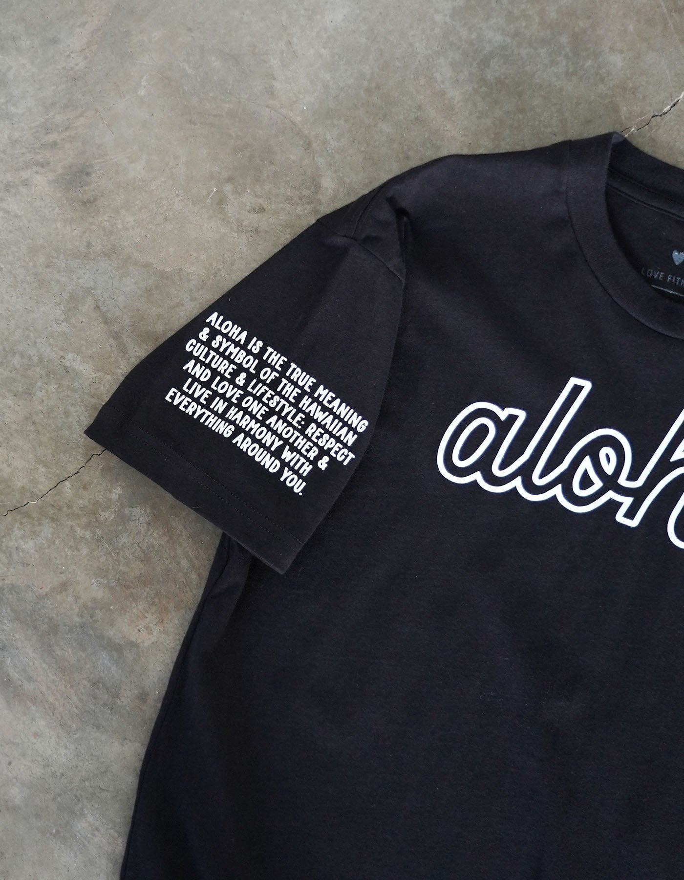 love fitness apparel aloha black tee and the aloha mantra printed on the right sleeve