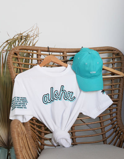 Crimson tavernorlando aloha every day white tee with the word aloha outlined and printed in two different colors black and teal paired with the dad hat in the color teal
