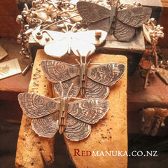 Jewellery nz | Purere Parangunu Peacock Moth Silver Brooch and necklace on bench peg