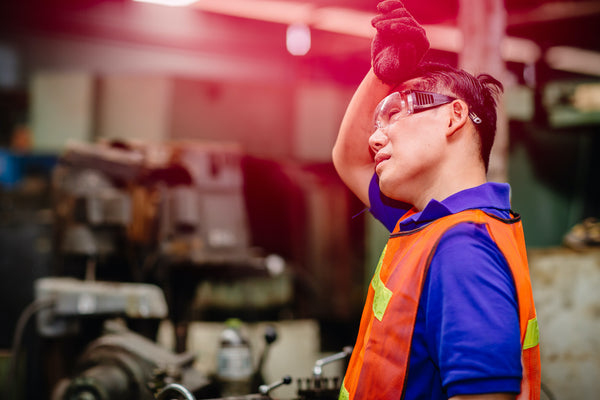 How long does heat exhaustion last: an outdoor worker in a safety vest struggles with the heat