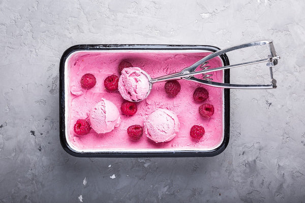 Best keto diet snacks: a tub of raspberry ice cream with an ice cream scooper