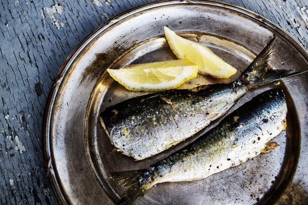 Best keto diet snacks: sardines on a plate with lemon wedges