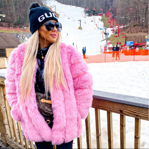 girl standing in snow wearing a Furever moscow pink faux fur coat