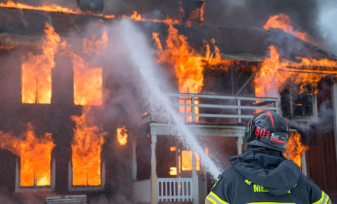 Firefighter trying to use water to stop a house fire