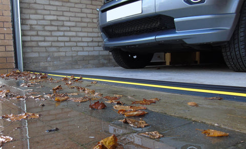 Garage door with an installed threshold seal with water outside