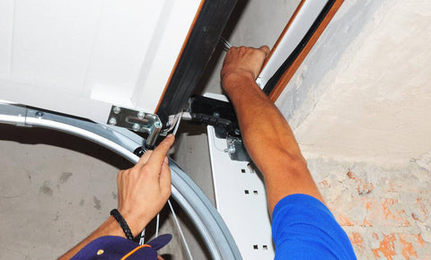 Man fixing the top of a garage door