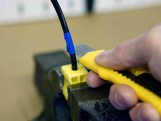 cutting hydraulic hose with a knife in a vice