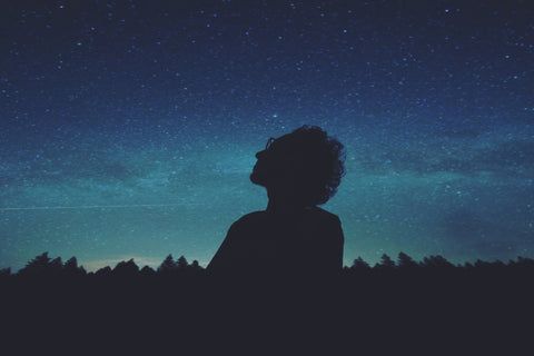 Man Looking at Stars in a Blue Sky 