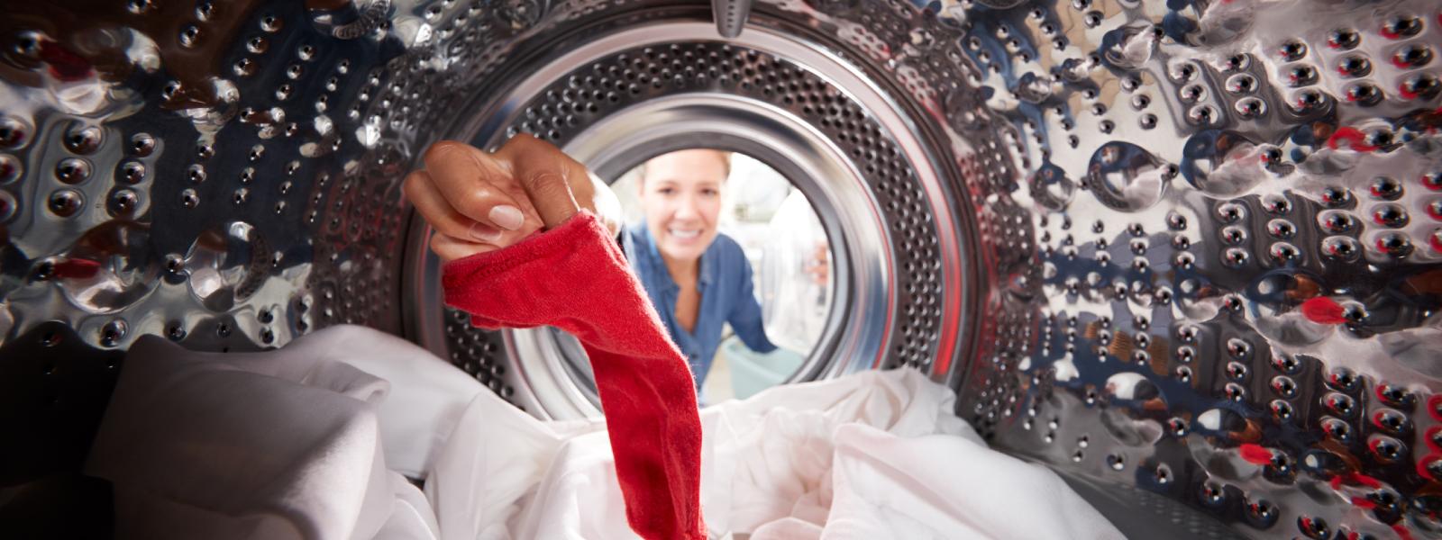 Femme regardant à l'intérieur de la machine à laver