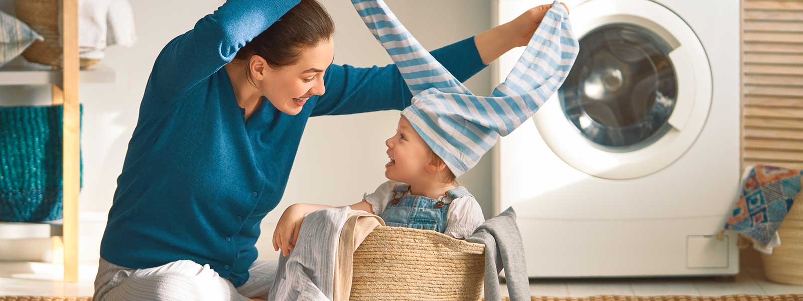 Une mère et son enfant qui rigole en triant le linge