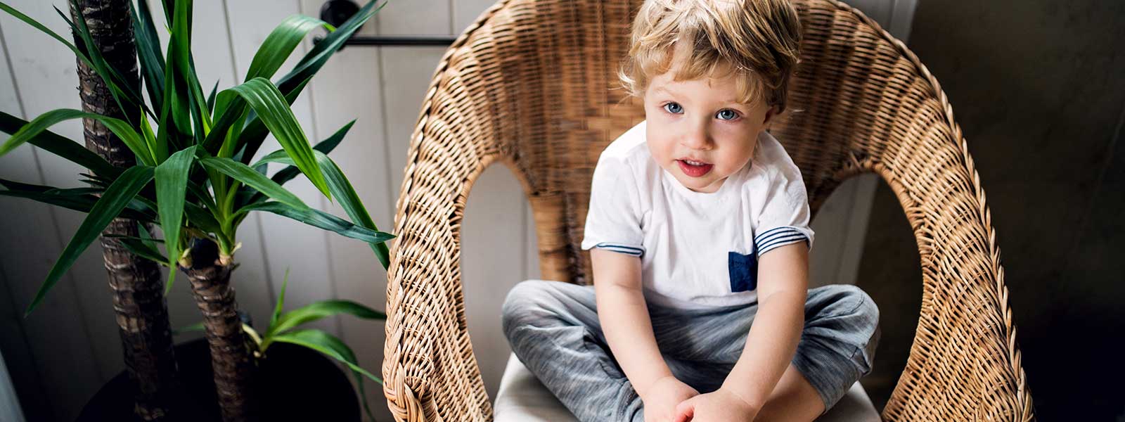 un fauteuil en osier avec un enfant assis