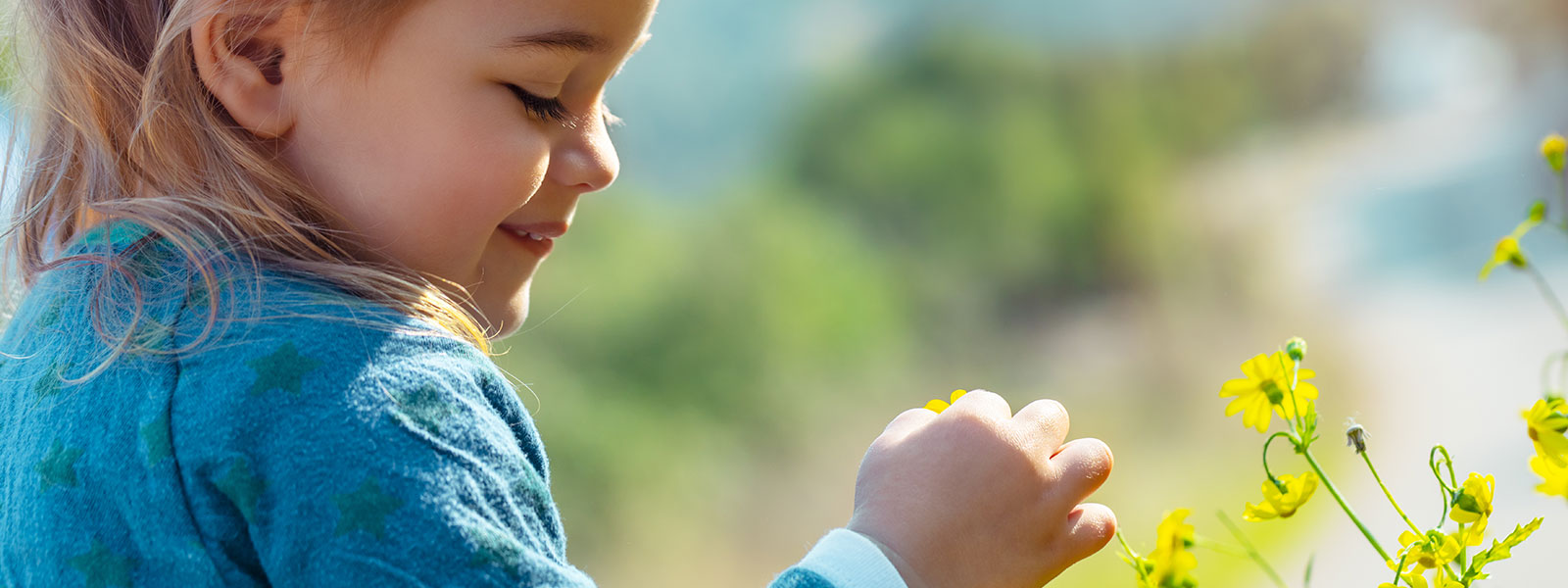 une petite fille qui découvre des fleurs