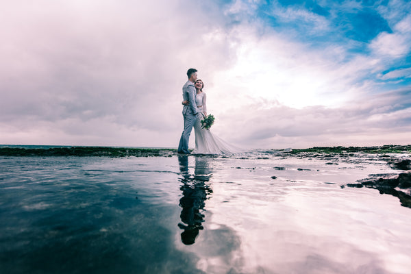 A married couple having a photograph on a beach during their wedding ceremony - Tim Downer Celebrant
