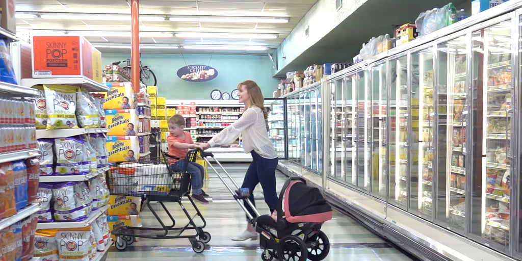 mother pushing child in shopping cart while pulling infant in Dash Wagon