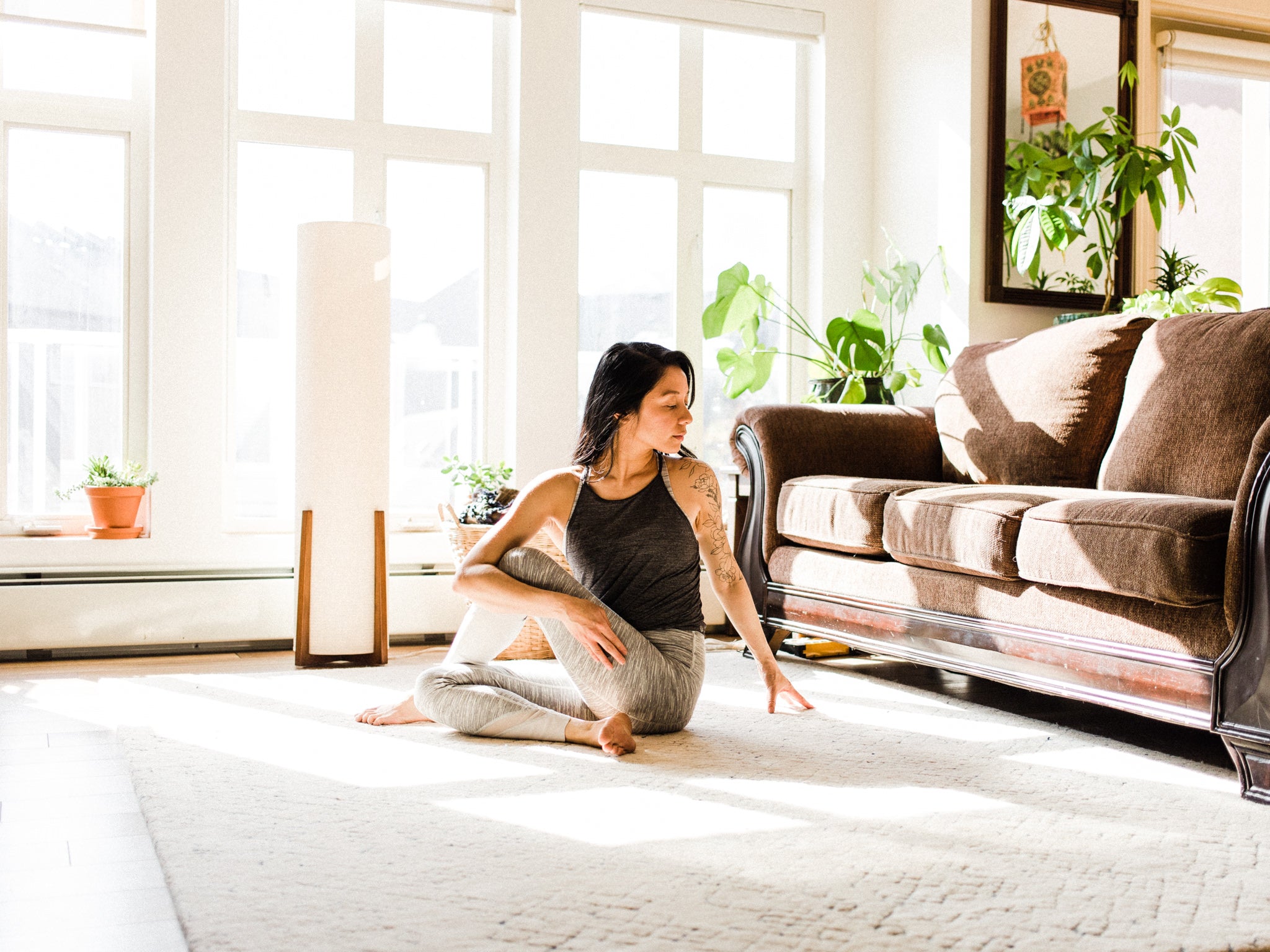 Woman practicing yoga in her living room. 