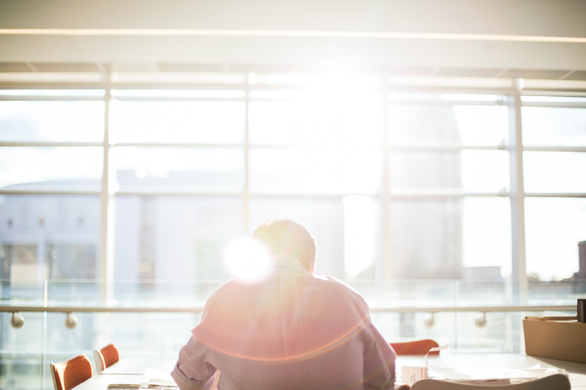 Man sitting at window in sunny office.