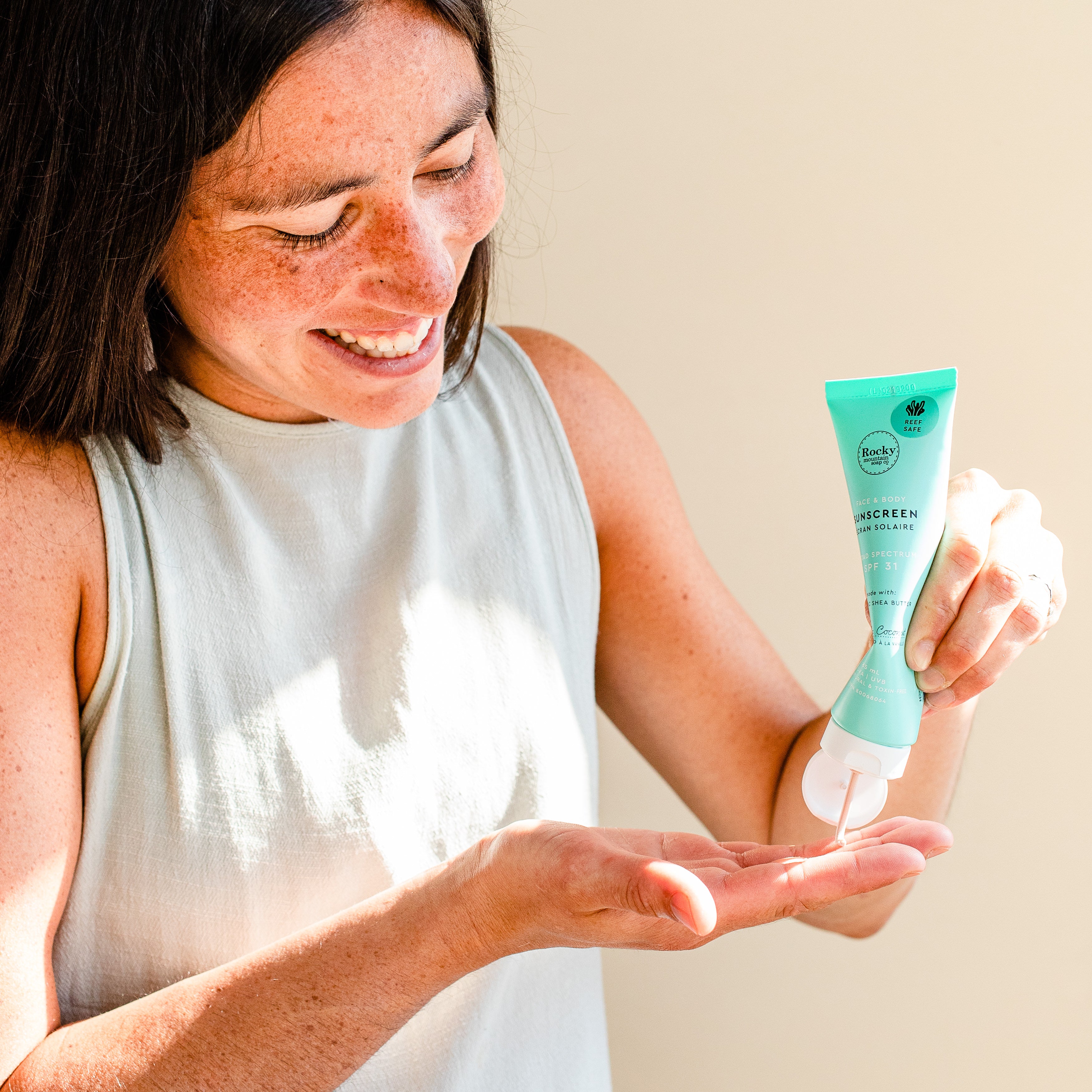 Woman putting all-natural sunscreen in her hand. 