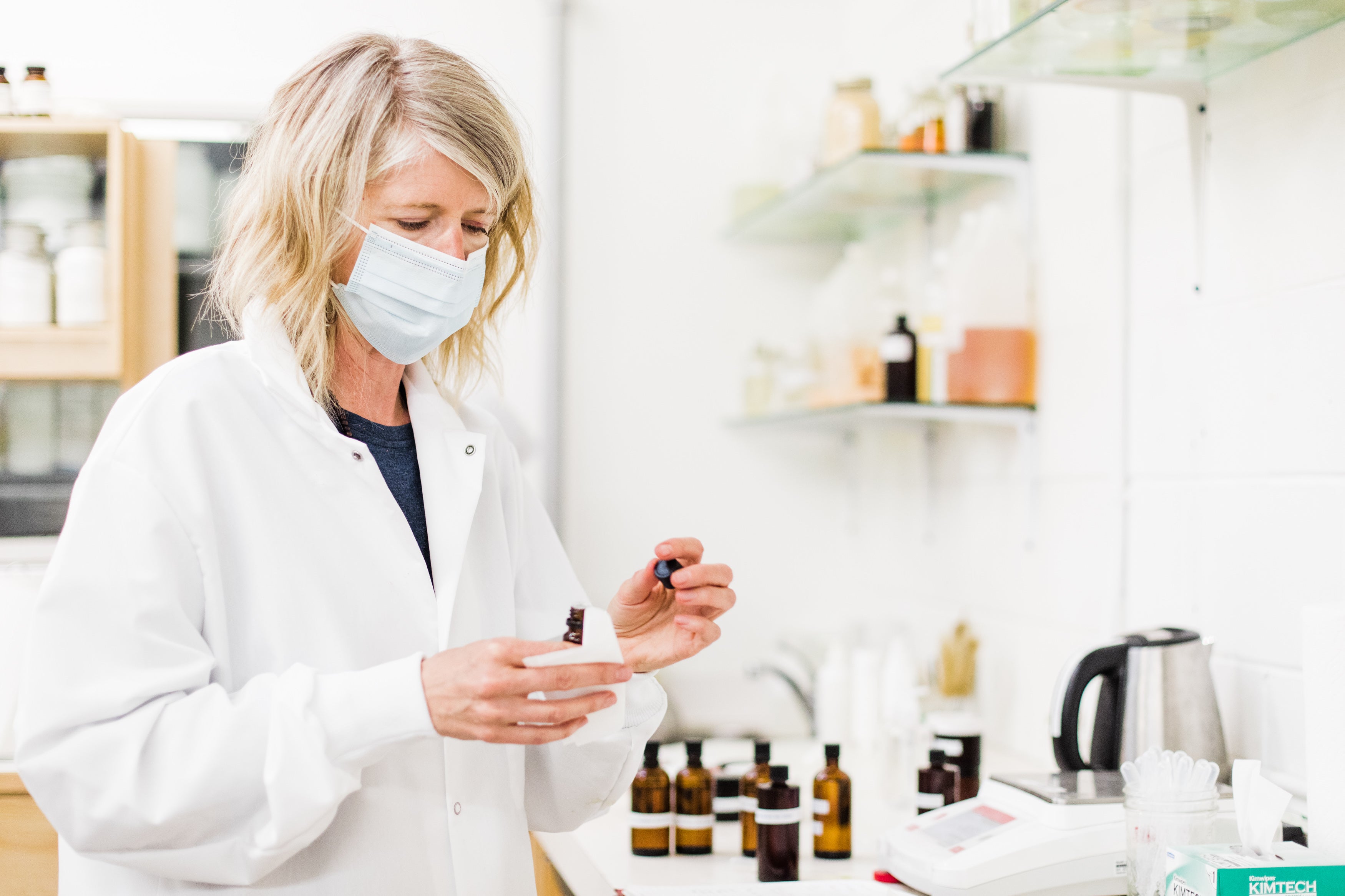 Image of woman in lab mixing essential oils.