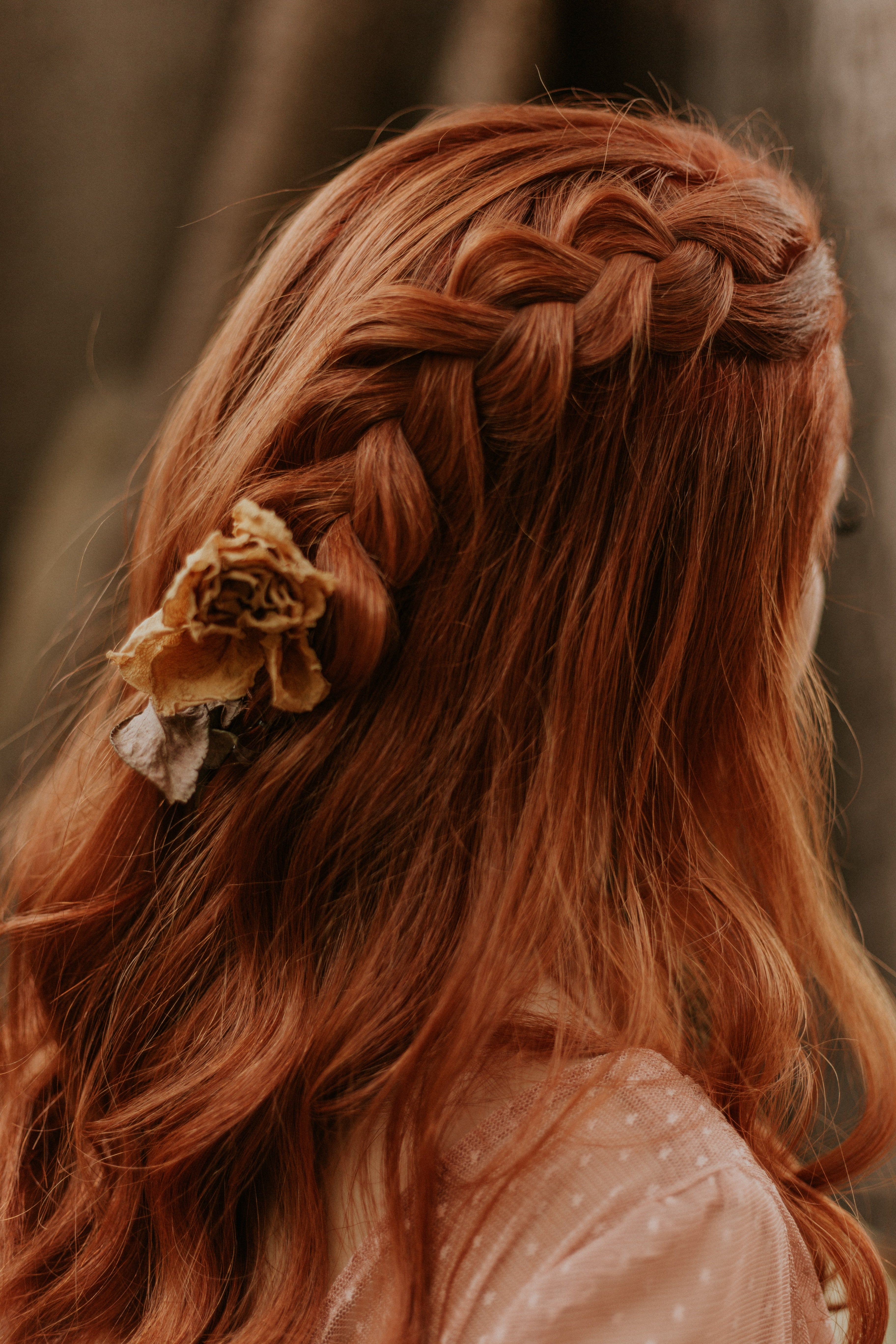 Red hair tied half in a braid and tied with a bow accessory as an idea for easy holiday hairstyles from Rocky Mountain Soap Company.  