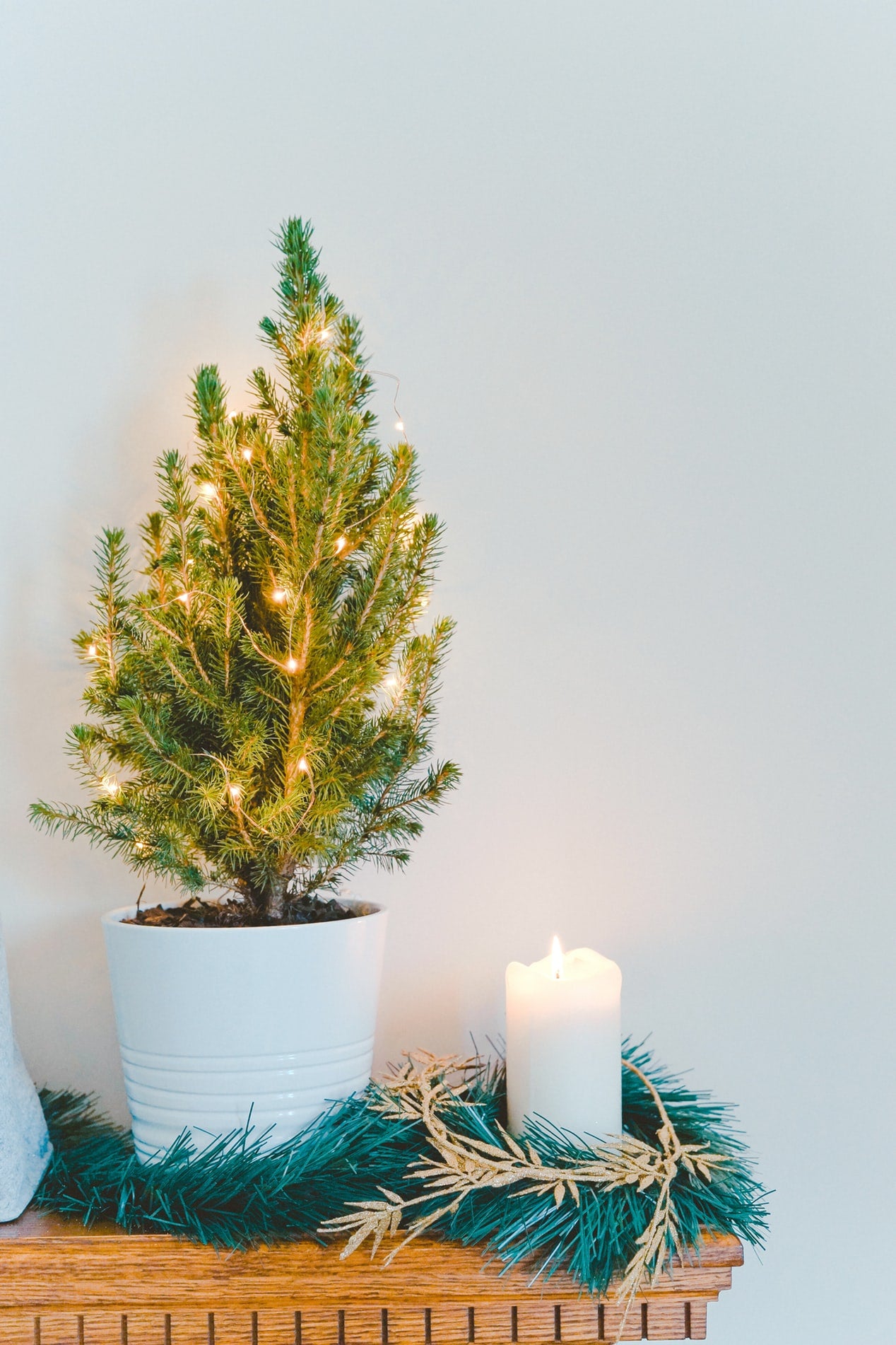 A small Christmas tree and candle create a festive atmosphere on the mantle when getting your home ready for the holidays. 