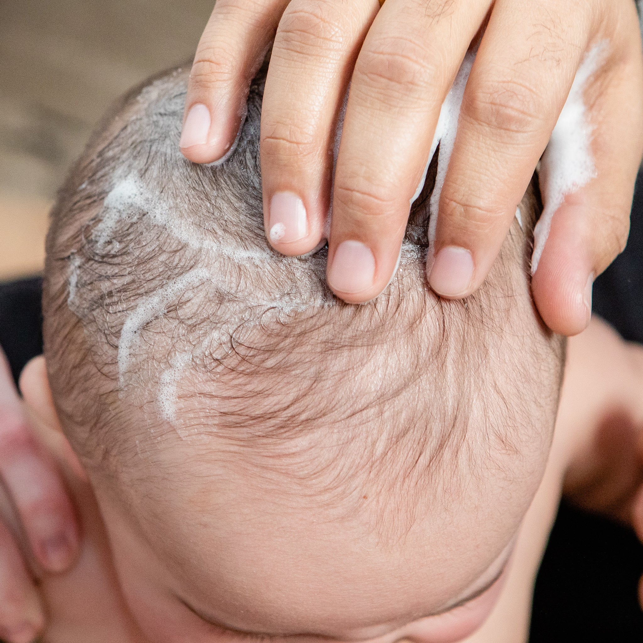 Baby's head being cleaned with all natural foaming wash. 