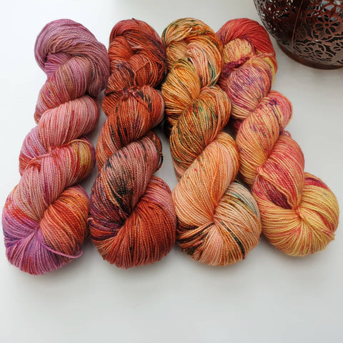 Four bright variegated skeins in pinks, oranges and yellows and lots of speckling. 