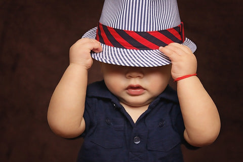 a little boy wearing a navy shirt and a cute matching hat.