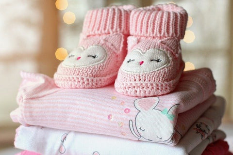 Nicely folded baby clothes, booties on top