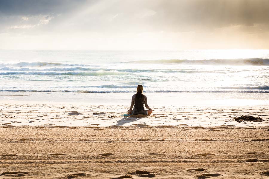 Woman sitting in the sun at the beach