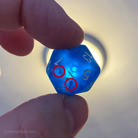 Air bubbles in transparent dice can be seen when held up to the light.